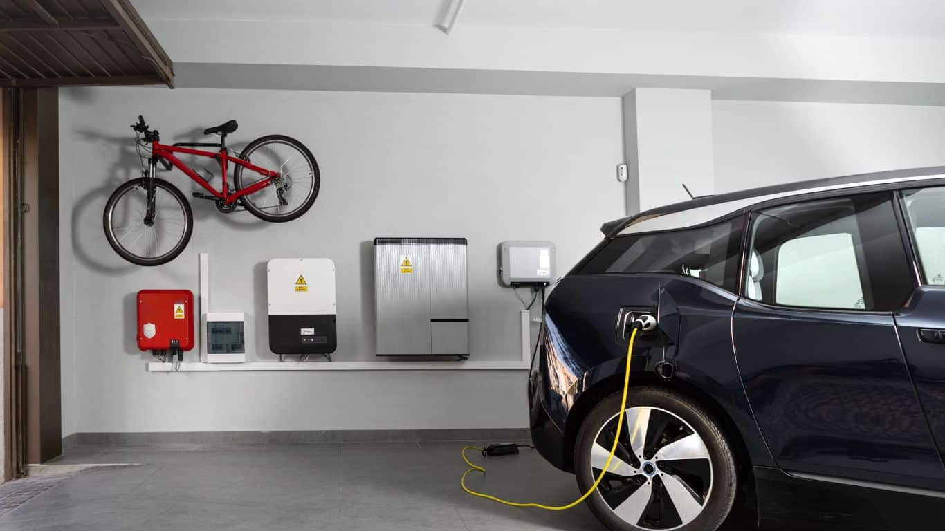 Close up fornt of black electric car charging at home inside a garage